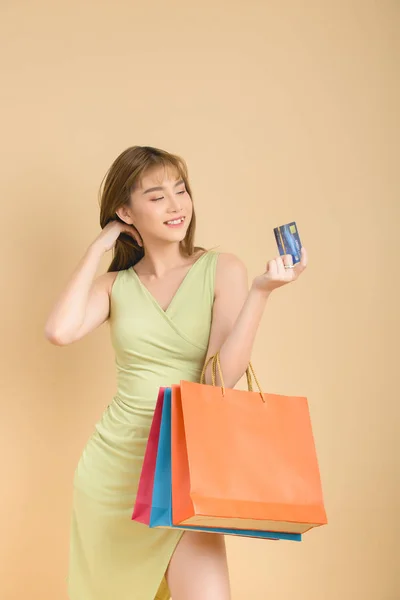 Mooie Aziatische vrouw met boodschappentas en creditcard in de hand — Stockfoto