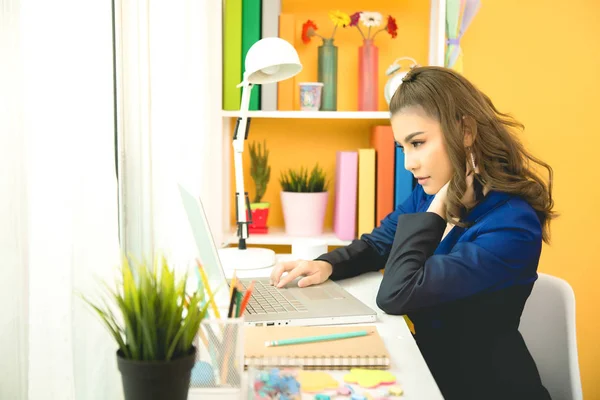 Senhora de negócios alegre trabalhando no laptop no escritório — Fotografia de Stock