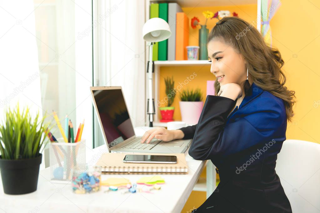 Cheerful business lady working on laptop in office