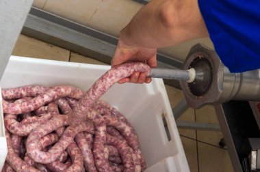 Closeup of production of sausages in meat shop clipart