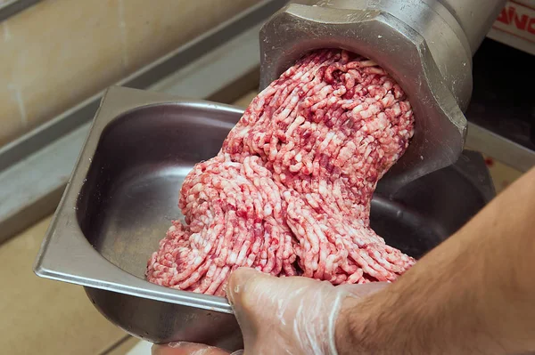 Closeup of production of minced meat in meat workshop