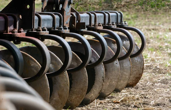 Closeup View Discs Harrow Row Placed Ground Green Field — Stock Photo, Image