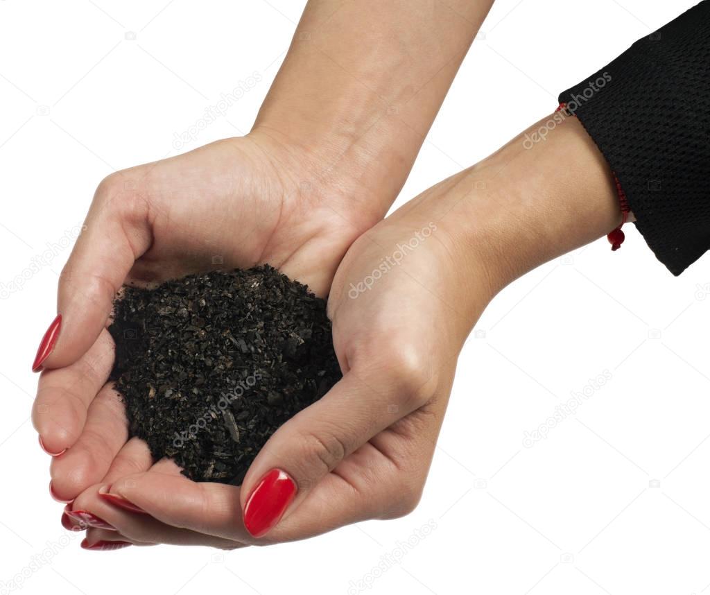Female hands holding coal fraction from recycling of automobile tires
