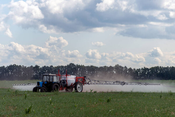  Трактор производит удобрения в летний день
 