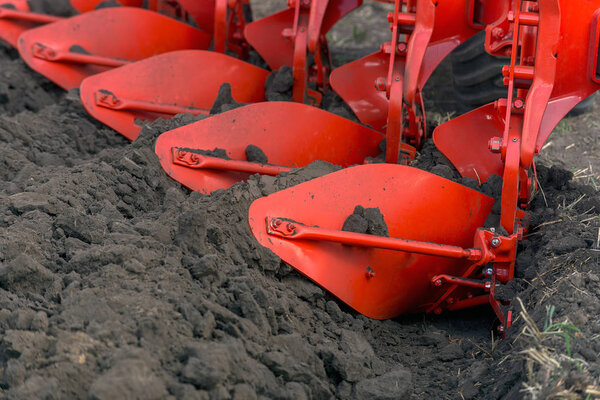 крупный план плуга, вспахивающего землю
