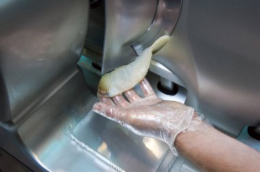 Şef balık kesiyor, dilimleyicide.