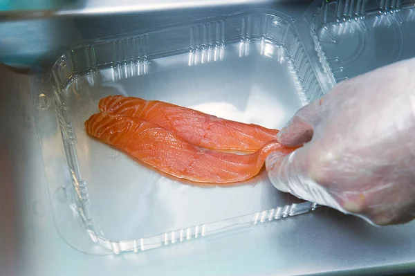 Koch schneidet Fisch, auf einem Aufschnittgerät — Stockfoto