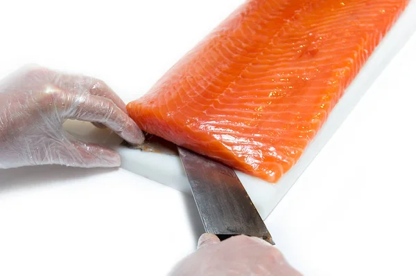 Chef cortando un pescado rojo por un chef, sobre un fondo blanco — Foto de Stock