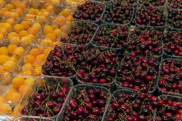 Verkauf von Kirschen und Aprikosenfrüchten auf dem Lebensmittelmarkt — Stockfoto