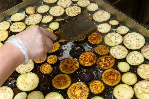 Работа шеф-повара, обжаривание баклажанов на плите — стоковое фото