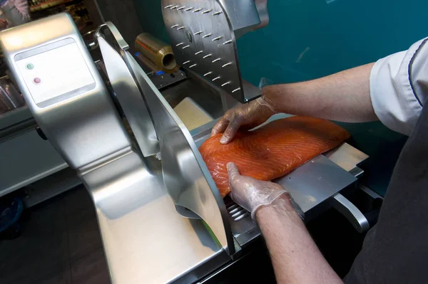 Chef cutting fish, on a slicer — ストック写真