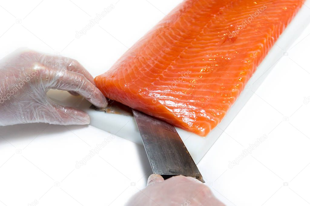 Chef cutting a red fish by a chef, on a white background