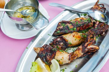 Sarımsak, zeytinyağı ile bir tabakta maydanoz ızgara kalamar