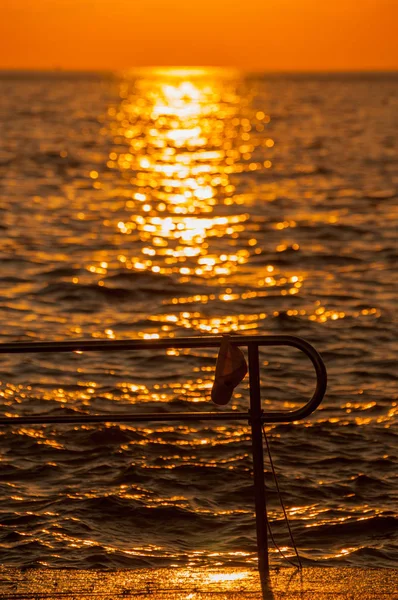 Hut an einem Stegzaun mit Reflexion der untergehenden Sonne in — Stockfoto