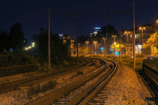 Curva de vías férreas por la noche en la ciudad — Foto de Stock