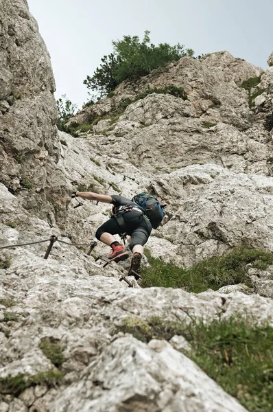 Mountain climber in steep vertical wall climbing the via ferrata in Julian Alps — Stock Photo, Image