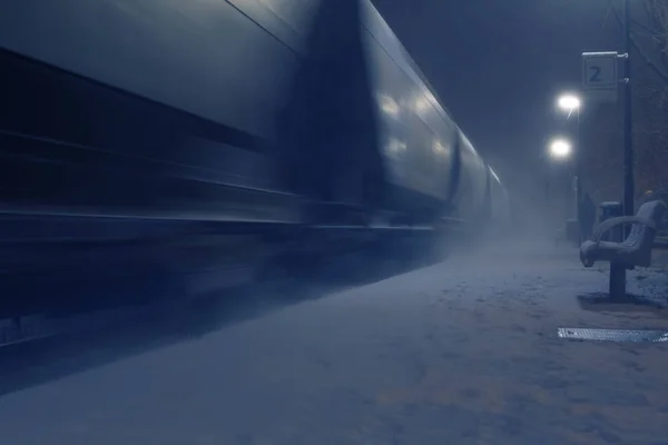 Treno merci in movimento sfocato alla stazione ferroviaria in una notte d'inverno — Foto Stock