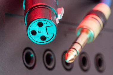 Dişi Xlr 3 pin konnektörü ve telefon prizli ses cihazının üzerinde asılı altın Trs telefon kablosu. Müzik, ses, hi-fi ve ses üretimi.
