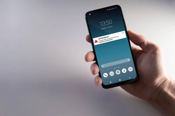 Karantina ihlali uyarısı Sloven dilinde erkek eliyle yapılan akıllı telefondan düzenlenmiş. Salgını durdurmak için ev karantinasında kalmanızı tavsiye ederim. Salgın, sağlık, teknoloji ve mahremiyet