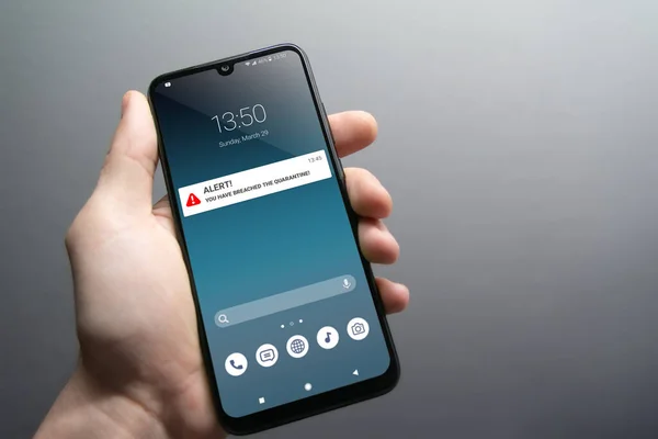 Karantina ihlali uyarısı erkek eliyle tutulan akıllı telefondan geliyor. Salgını durdurmak için ev karantinasında kalmanızı tavsiye ederim. Salgın, sağlık, teknoloji ve mahremiyet