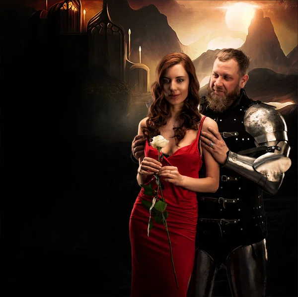 Όμορφο κορίτσι με κόκκινο φόρεμα και ιππότης με πανοπλία. — Φωτογραφία Αρχείου