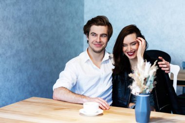 Bir kafedeki güzel çift kahve içer ve bir şeyler hakkında konuşur.