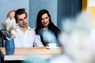 Bir kafedeki güzel çift kahve içer ve bir şeyler hakkında konuşur.