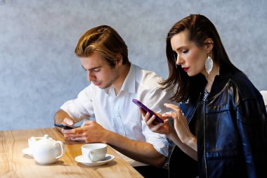 Bir kafedeki güzel çift kahve içer ve onun telefonundan bir şeyler izlerdi.