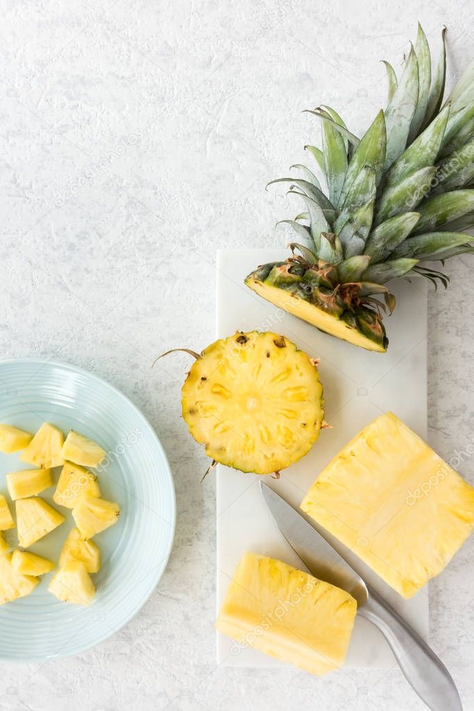 Fresh cut Pineapple pieces on Plate and Marble Chopping Board