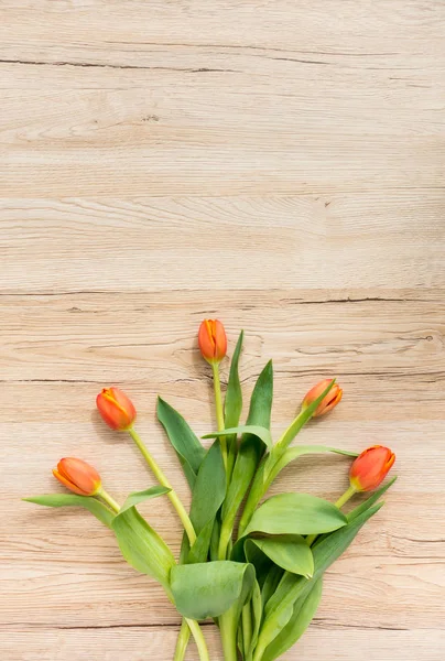 Cinco tulipas laranja no fundo de madeira marrom — Fotografia de Stock