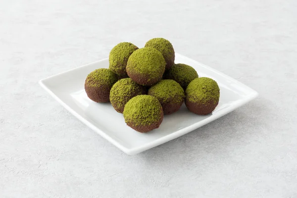Yeşil Matcha enerji topları beyaz plaka üzerinde 