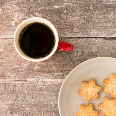 Kahverengi taşralı ağaçların üzerinde noel kurabiyeleri ve kahve kupası.