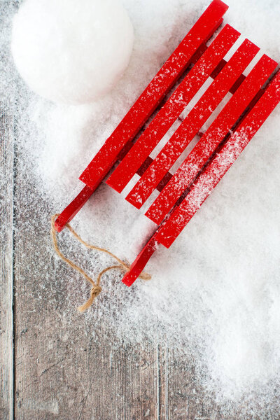 Top view of Red Sledge and Snowball in Snow and on Wood