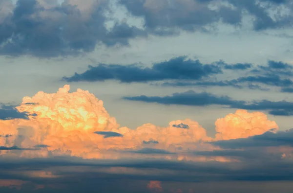 orange and blue cumulus and spindrift clouds, highlighted by the