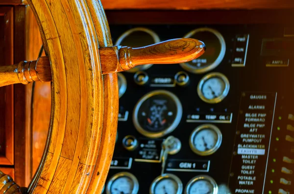 Yellow, old, lacquered, wooden steering wheel on a marine yacht,