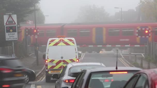 Un passaggio a livello a Motspur Park, Regno Unito, giornata nebbiosa — Video Stock