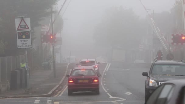 Un passaggio a livello a Motspur Park, Regno Unito, giornata nebbiosa — Video Stock