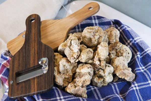 White truffles on cloth with truffle cut in wood