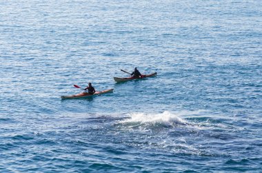 Bir kayık denize yakın bir girdap içinde iki kişi