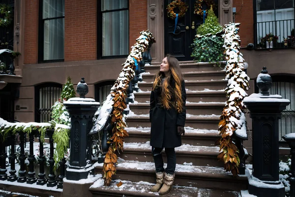 Genç kadınlarda soğuk kış New York'taki evinin verandada duran ve gülümseyen Noel sabahı. Bir kişi