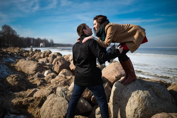 お互いを見て 冬のシーズンの海岸線でキスをする準備ができてのエレガントな服の若い美しいカップル 晴れた日に — ストック写真