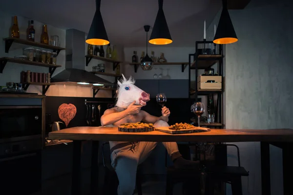 Funny unicorn sits alone at the bar counter in stylish apartment