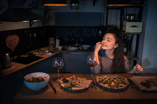 Fiatal nő csukott szemmel ül az asztalnál, az élelmiszer — Stock Fotó