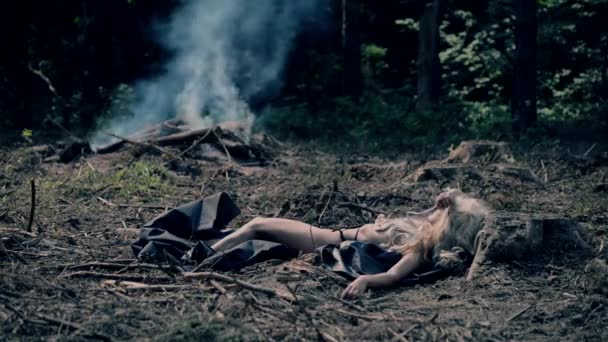 Sexy girl sunbathing against the backdrop of bonfire and twigs — Stock Video