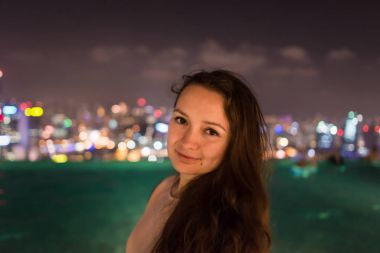 Genç ve güzel kadın Marina Bay Sands çatıda duruyor