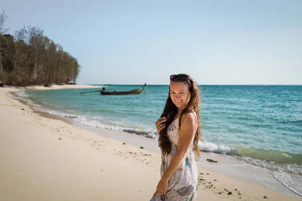 Mujer joven en vestido es caminar en la playa en la costa del océano — Foto de Stock