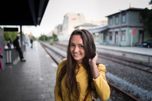 Joven linda mujer en brillante vestido se para en la estación de tren — Foto de Stock