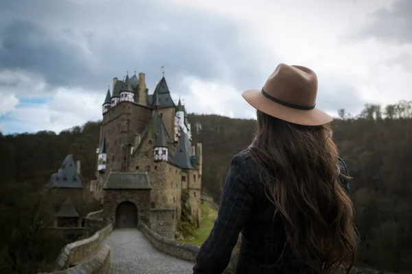 Onherkenbaar jongedame wandelingen langs de weg die leidt naar een ongelooflijke kasteel — Stockfoto