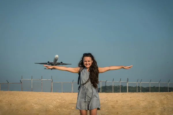 Jet avión despega en el fondo detrás de una joven mujer — Foto de Stock