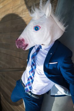 Şık takım elbise ve komik maskesi çok yorgun genç Yöneticisi bankta rahatlatır